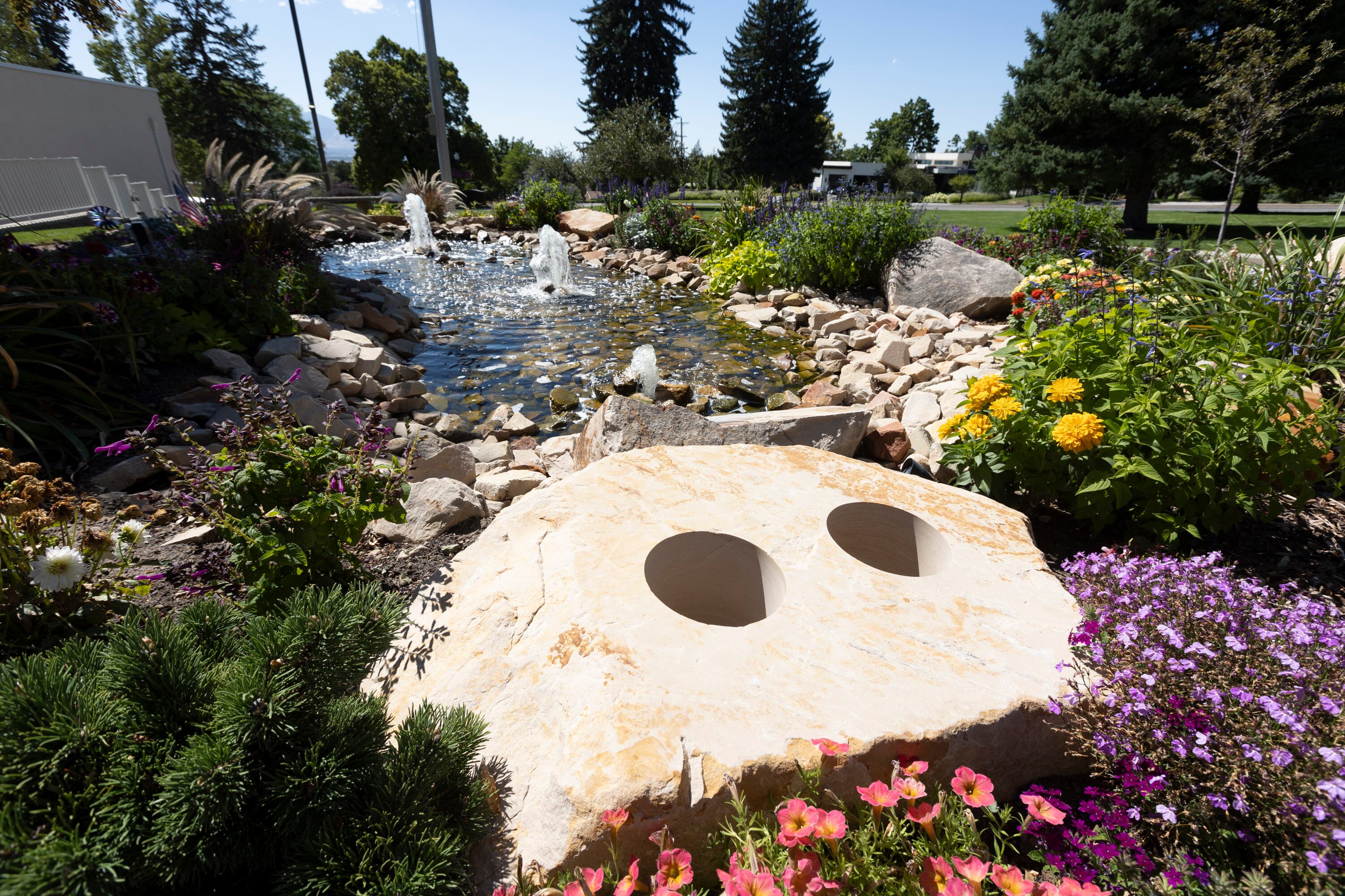 A boulder with bored holes for cremated cremains sit in a memory garden at Larkin Sunset Lawn Mortuary, Mausoleum, Cemetery and Crematorium in Salt Lake City on Aug. 16.