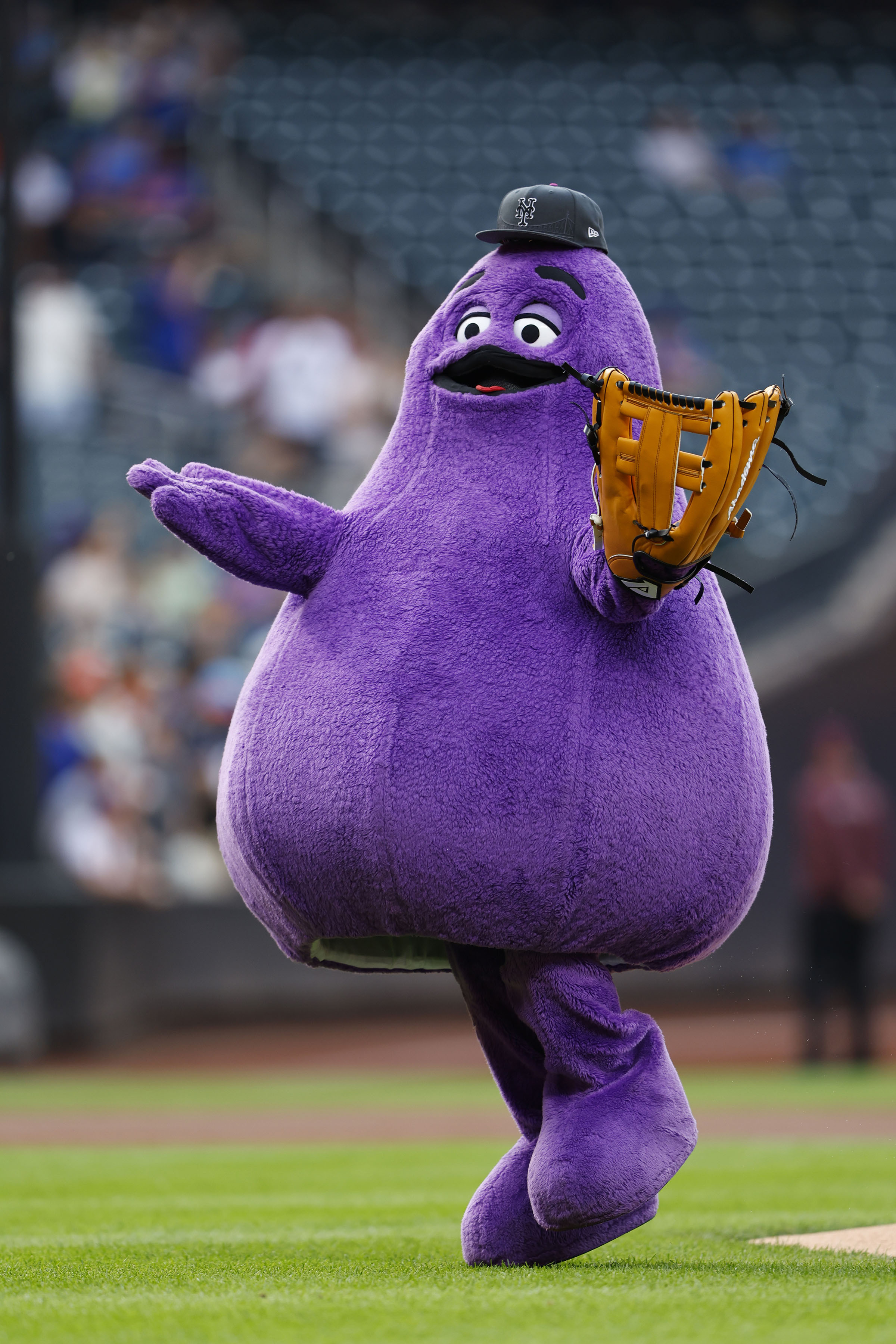 FILE - McDonald's character Grimace throws out a ceremonial first pitch before a baseball game between the Miami Marlins and the New York Mets, June 12, 2024, in New York.