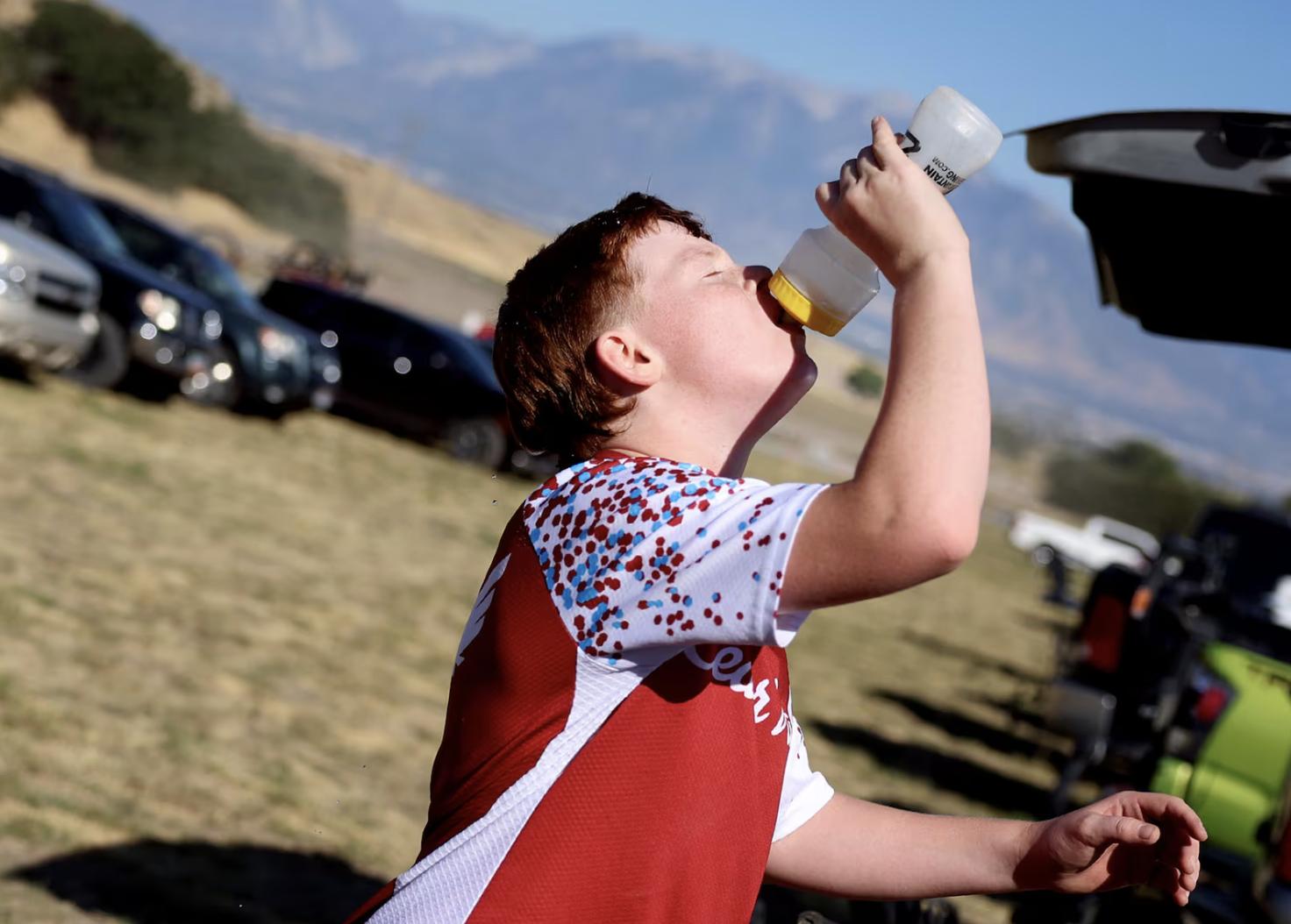 Enoch Watters with the Cedar Valley cycling team drinks water after practicing for an upcoming race at Butterfield Canyon in Herriman on Friday.