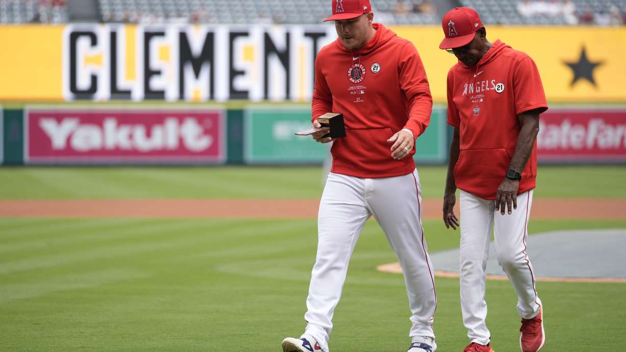 Los Angeles Angels' Mike Trout, left, is recognized as the Angels' 2024 Roberto Clemente Award nominee before a baseball game against the Houston Astros in Anaheim, Calif., Sunday, Sept. 15, 2024. At right is manager Ron Washington.