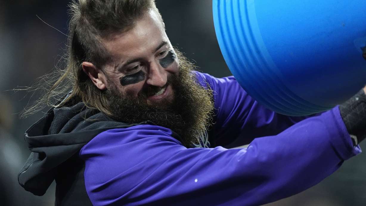 Colorado Rockies' Charlie Blackmon smiles as he tries to douse television analyst Ryan Spilborghs after the Rockies' walkoff victory over the Arizona Diamondbacks in a baseball game Monday, Sept. 16, 2024, in Denver.