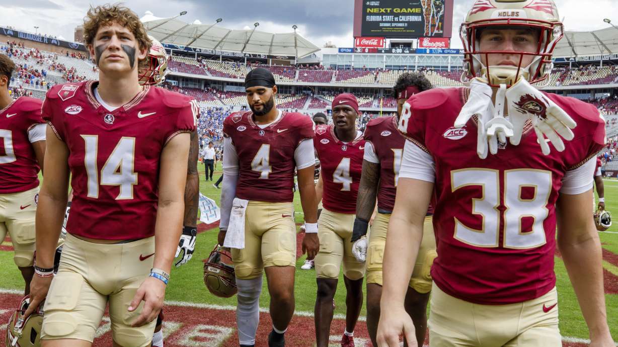Florida State quarterbacks Luke Kromenhoek (14), DJ Uiagalelei (4), defensive back Charles Lester III (4) and defensive back Cade Papineau (38) walk off the field after losing 20-12 to Memphis in an NCAA college football game, Saturday, Sept. 14, 2024, in Tallahassee, Fla.