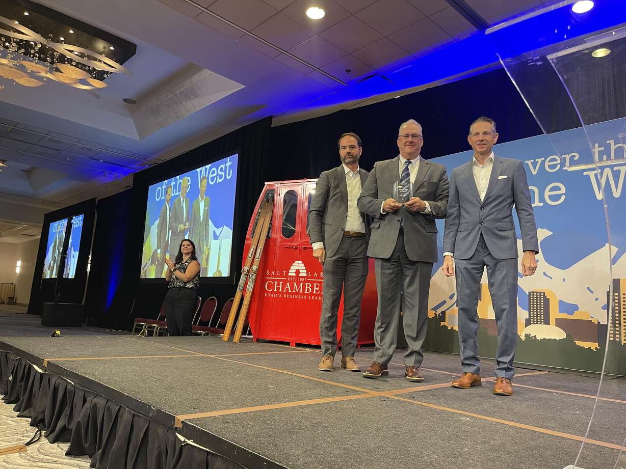 Nate Hatch, president of Deseret Digital Media, receives the President's Award in Excellence from Nathan Callister and Derek Miller during the Salt Lake Chamber's annual meeting on Tuesday.