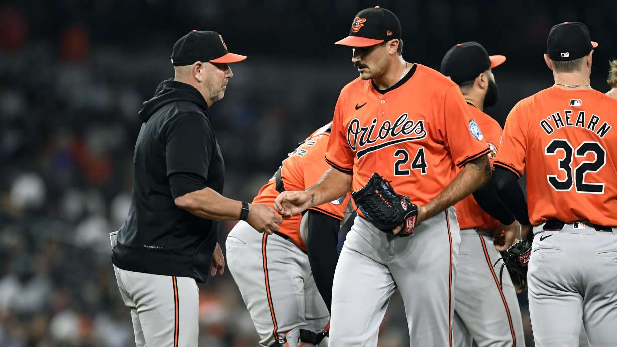 Baltimore Orioles manager Brandon Hyde, left, takes the ball from starting pitcher Zach Eflin (24) in the seventh inning of a baseball game against the Detroit Tigers, Friday, Sept. 13, 2024, in Detroit.
