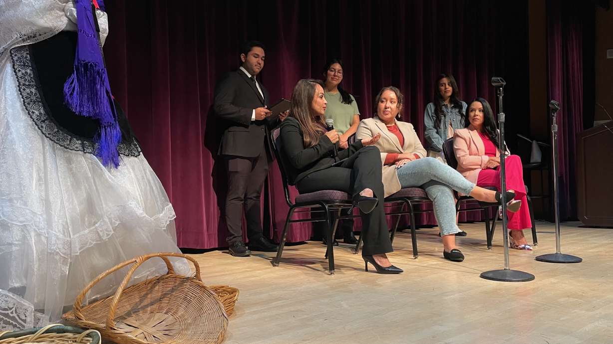 Yudi Vargas Lewis, of Weber State University, addresses a Hispanic Heritage Month event at the Ogden school on Tuesday. Seated on the stage with her are Laís Martinez, center, and Nubia Peña.