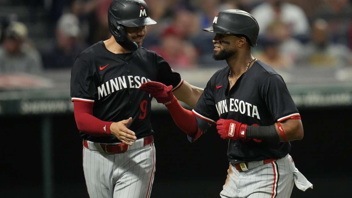 Minnesota Twins' Trevor Larnach, left, congratulates Willi Castro, on his home run in the eighth inning of a baseball game against the Cleveland Guardians, Tuesday, Sept. 17, 2024, in Cleveland.