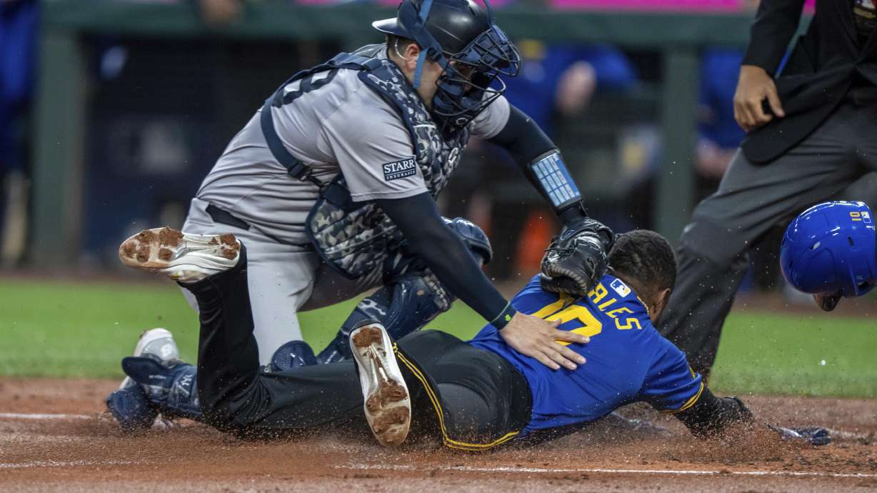 New York Yankees catcher Austin Wells tags out Seattle Mariners' Victor Robles attempting to steal home plate during the first inning of a baseball game, Tuesday, Sept. 17, 2024, in Seattle.