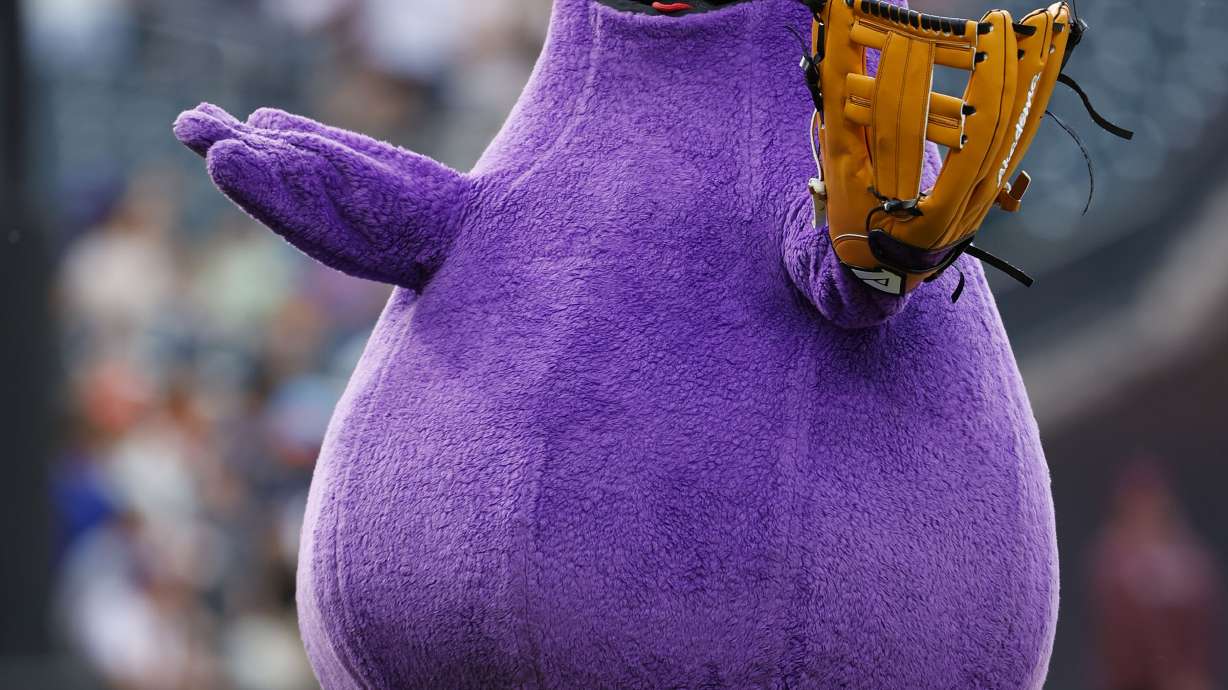 FILE - McDonald's character Grimace throws out a ceremonial first pitch before a baseball game between the Miami Marlins and the New York Mets, June 12, 2024, in New York.