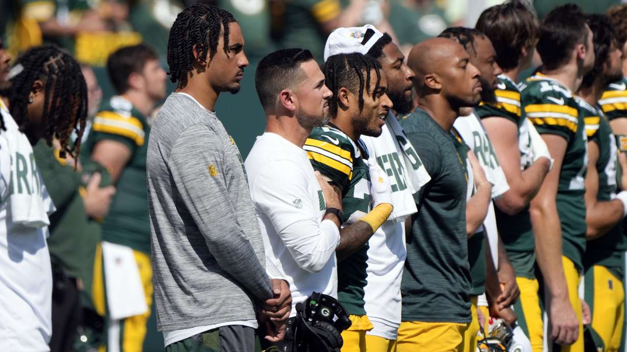 Injured Green Bay Packers quarterback Jordan Love, left, stans with his temamtes for the Natioanl Anthem before the start of an NFL football game against the Indianapolis Colts Sunday, Sept. 15, 2024, in Green Bay, Wis.