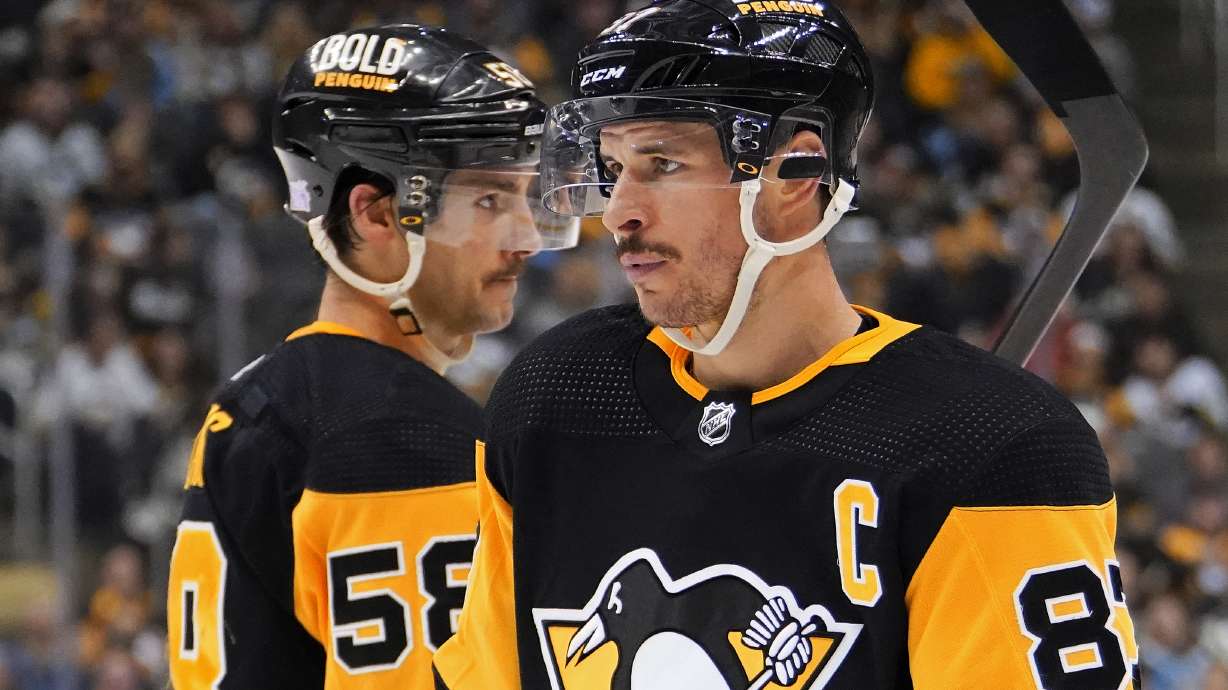 FILE - Pittsburgh Penguins' Sidney Crosby (87) and Kris Letang (58) play in an NHL hockey game against the Vancouver Canucks in Pittsburgh, Wednesday, Nov. 24, 2021.