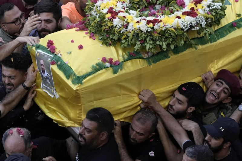 Hezbollah fighters carry one of the coffins of four fallen comrades who were killed Tuesday after their handheld pagers exploded, in the southern suburb of Beirut, Lebanon, Wednesday.