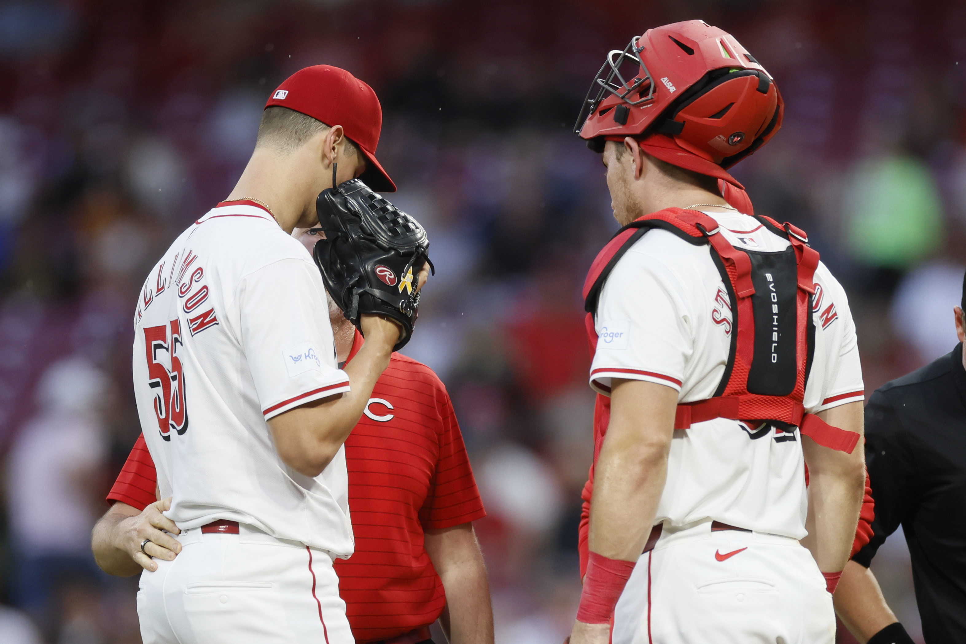 Cincinnati Reds starting pitcher Brandon Williamson, left, talks with catcher Tyler Stephenson and a trainer before being taken out of the game with an injury against the Atlanta Braves during the second inning of a baseball game Tuesday, Sept. 17, 2024, in Cincinnati.