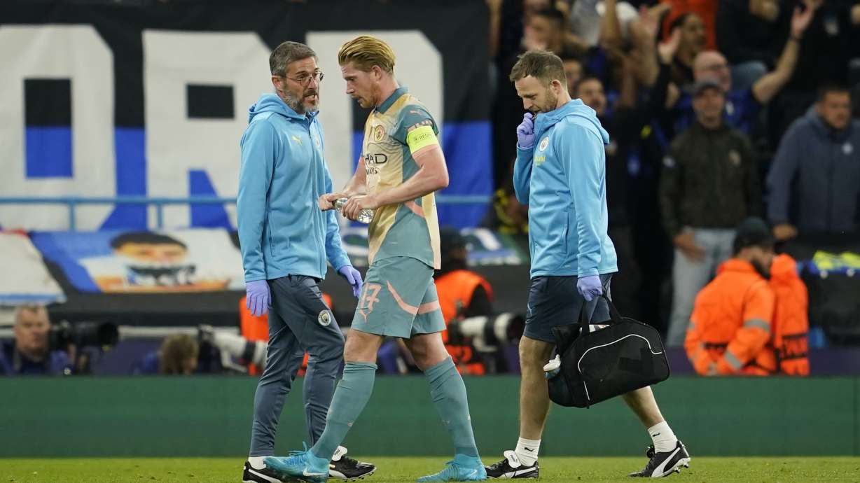 Manchester City's Kevin De Bruyne, center, gestures as he speaks medical staff end of the first half during the Champions League opening phase soccer match between Manchester City and Inter Milan at the Etihad Stadium, in Manchester, England, Wednesday, Sept. 18, 2024.