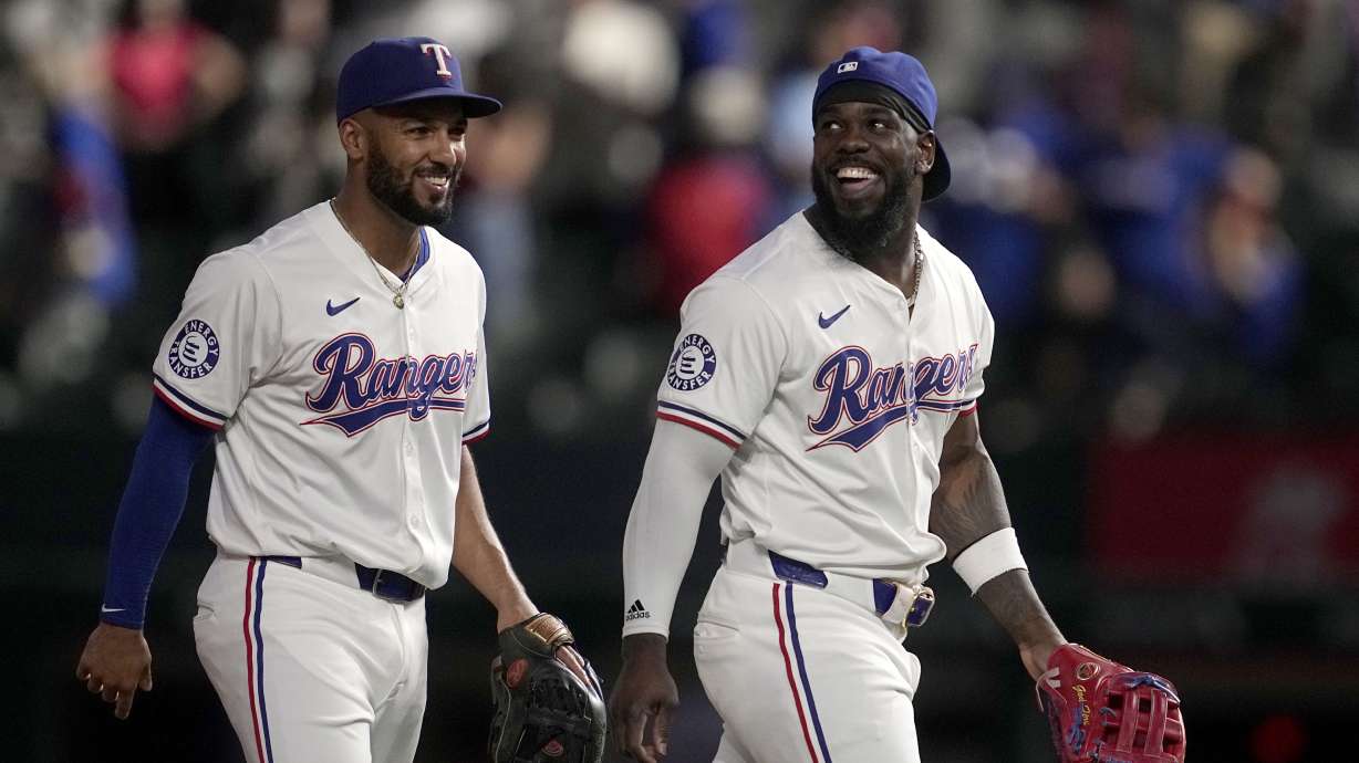 Texas Rangers' Marcus Semien, left, and Adolis Garcia walk off the field after their team's win against the Toronto Blue Jays in a baseball game in Arlington, Texas, Wednesday, Sept. 18, 2024.