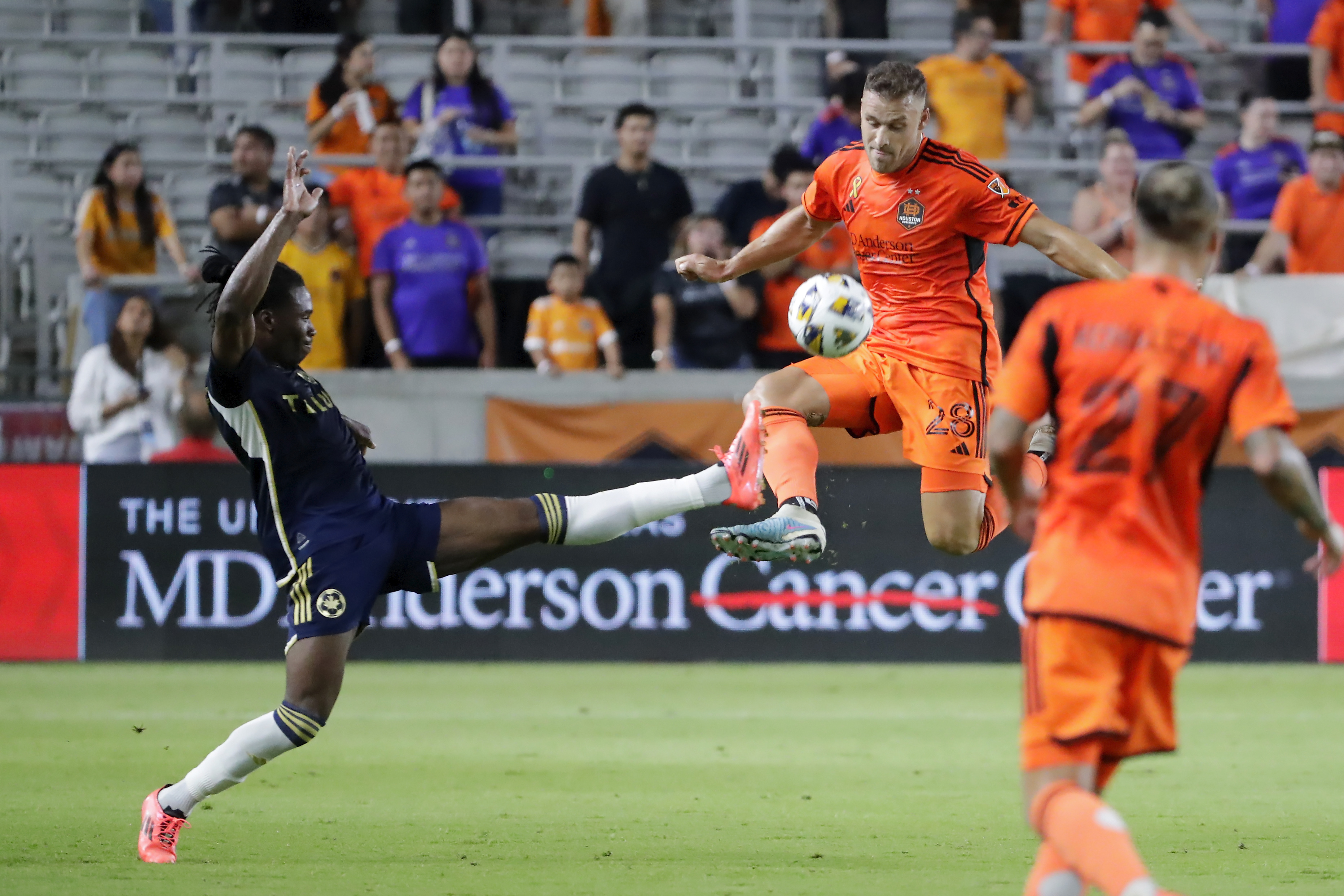 Vancouver Whitecaps defender Sam Adekugbe, left, kicks away as Houston Dynamo defender Erik Sviatchenko, center right, tries to block as midfielder Sebastian Kowalczyk looks on during the first half of an MLS soccer match, Wednesday, Sept. 18, 2024, in Houston.