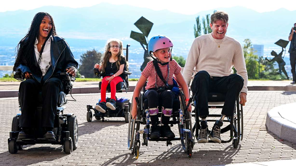 Tara Davis-Woodhall and Hunter Woodhall chase down Madi Sandstrom as they race during a visit to Shriners Children’s Hospital in Salt Lake City on Wednesday. Hunter Woodhall was a patient at the hospital when he was younger.