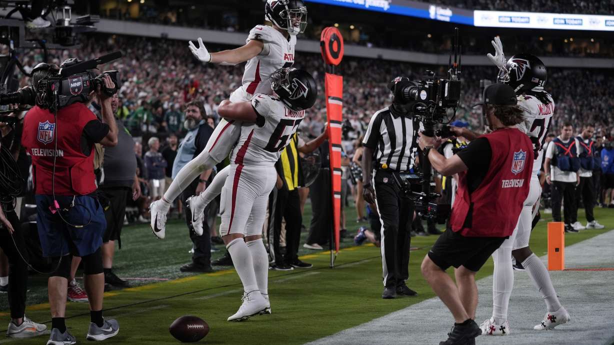 Atlanta Falcons wide receiver Drake London (5) celebrates his touchdown with teammate Chris Lindstrom (63) during the second half of an NFL football game against the Philadelphia Eagles on Monday, Sept. 16, 2024, in Philadelphia.