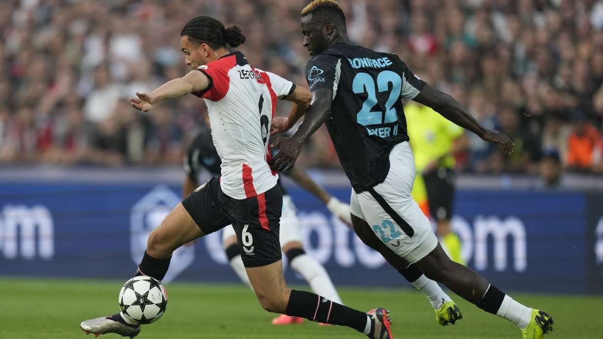 Feyenoord's Ramiz Zerrouki, left, and Leverkusen's Victor Boniface fight for the ball during the Champions League opening phase soccer match between Feyenoord and Leverkusen in Rotterdam, Netherlands, Thursday, Sept. 19, 2024.
