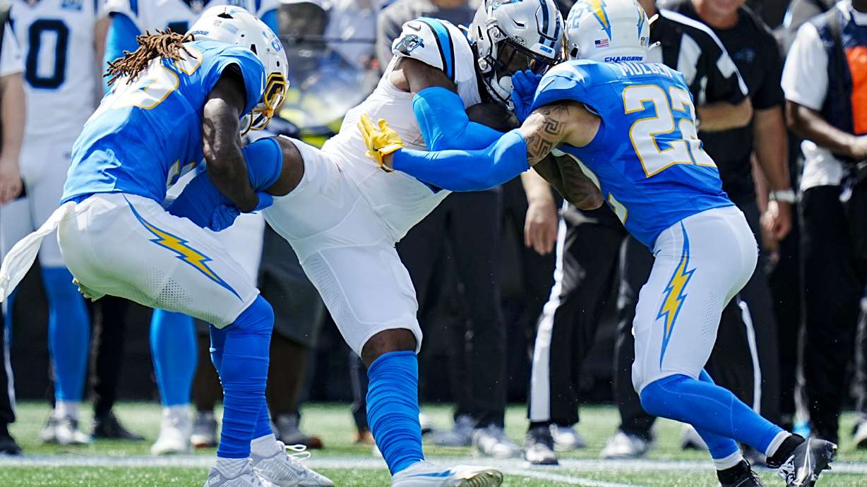 Carolina Panthers tight end Ja'Tavion Sanders is tackled by Los Angeles Chargers cornerback Ja'Sir Taylor and cornerback Elijah Molden during the first half of an NFL football game on Sunday, Sept. 15, 2024, in Charlotte, N.C.