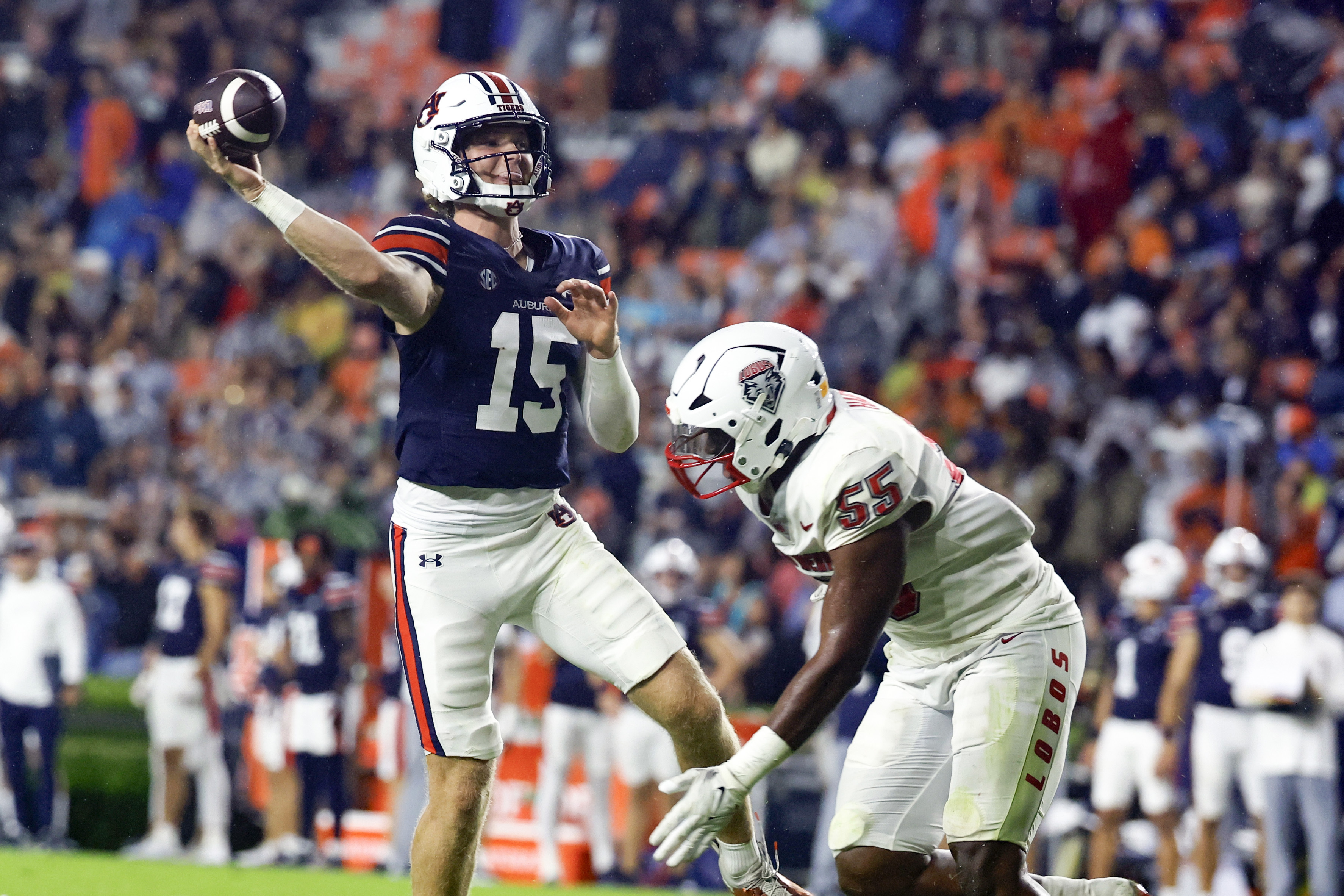 Auburn quarterback Hank Brown (15) looks to throw a pass for a touchdown as New Mexico edge Antoineo Harris Jr. (55) pressures him during the second half of an NCAA college football game, Saturday, Sept. 14, 2024, in Auburn, Ala.