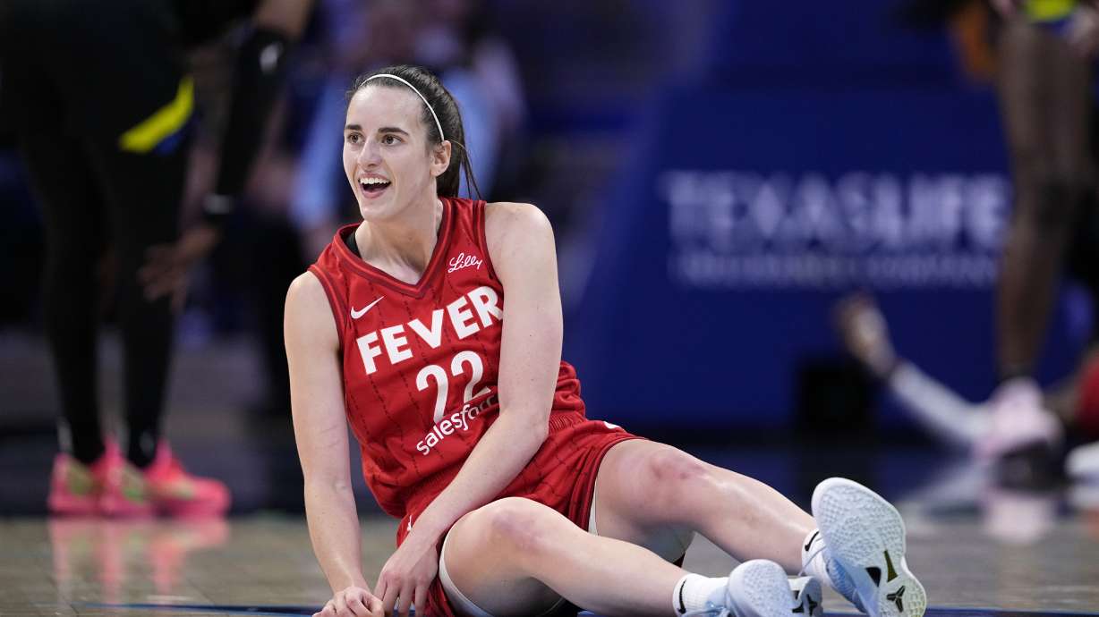 Indiana Fever guard Caitlin Clark smiles as she looks to the team bench after making a pass to the basket that lead to a score in the second half of a WNBA basketball game against the Dallas Wings Sunday, Sept. 1, 2024, in Arlington, Texas.