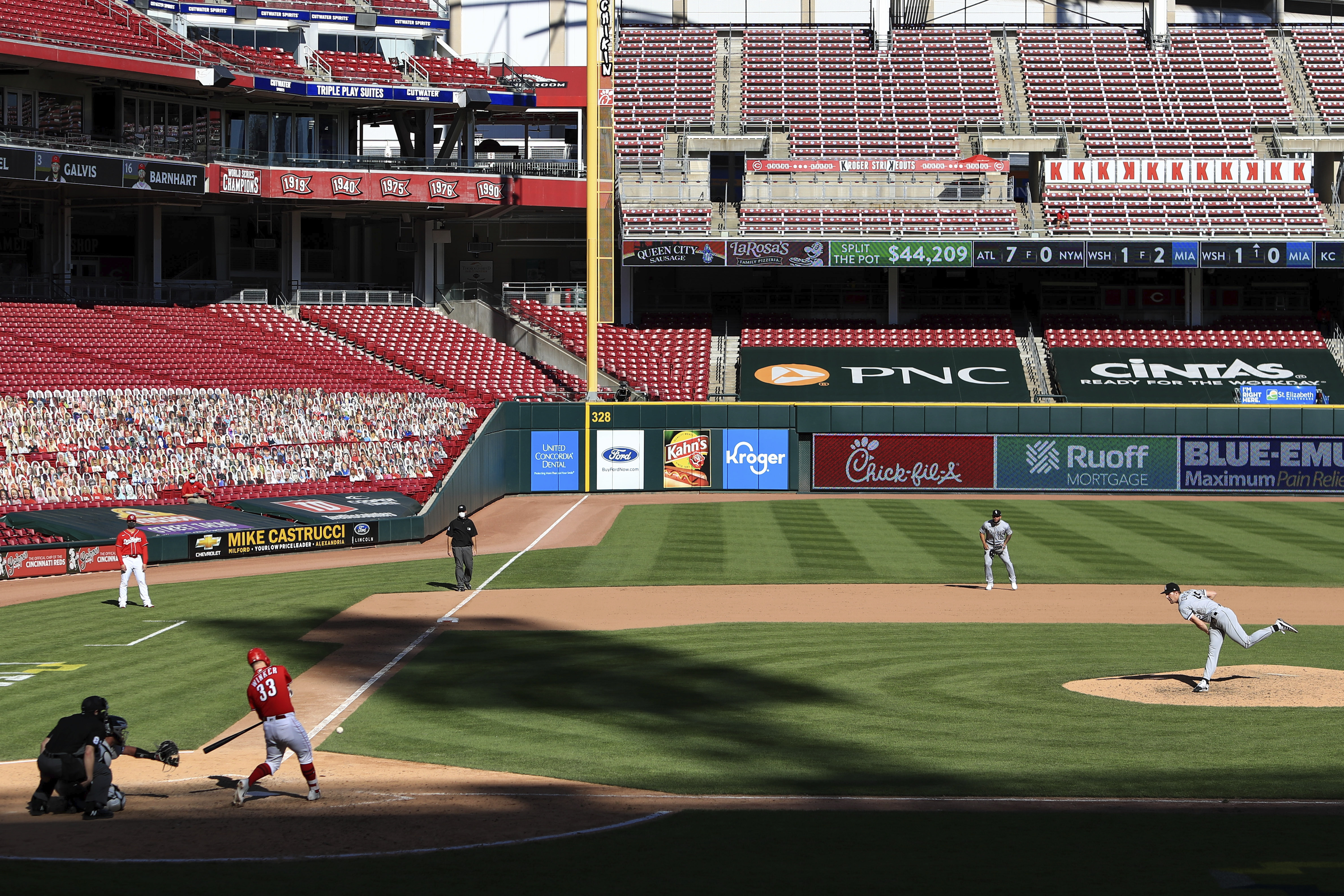 FILE - Cincinnati Reds' Jesse Winker, left, hits a single of a pitch thrown by Chicago White Sox' Garrett Crochet, right, during a baseball game in Cincinnati, Sunday, Sept. 20, 2020. 