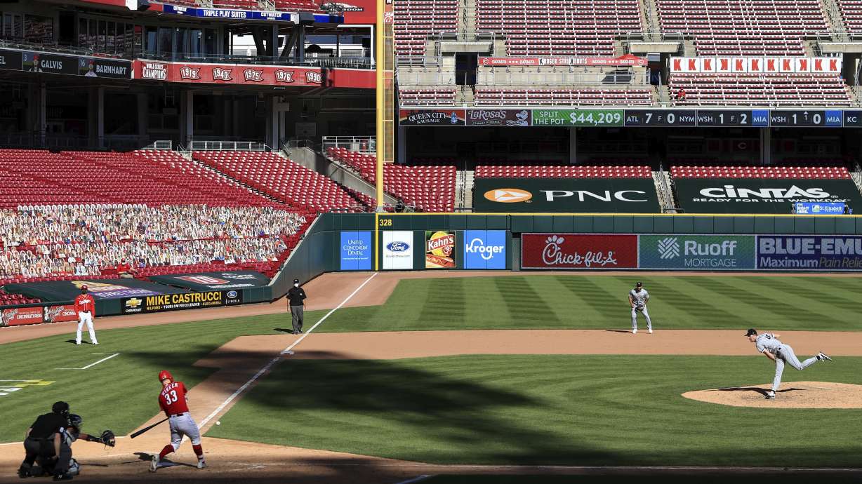 FILE - Cincinnati Reds' Jesse Winker, left, hits a single of a pitch thrown by Chicago White Sox' Garrett Crochet, right, during a baseball game in Cincinnati, Sunday, Sept. 20, 2020.