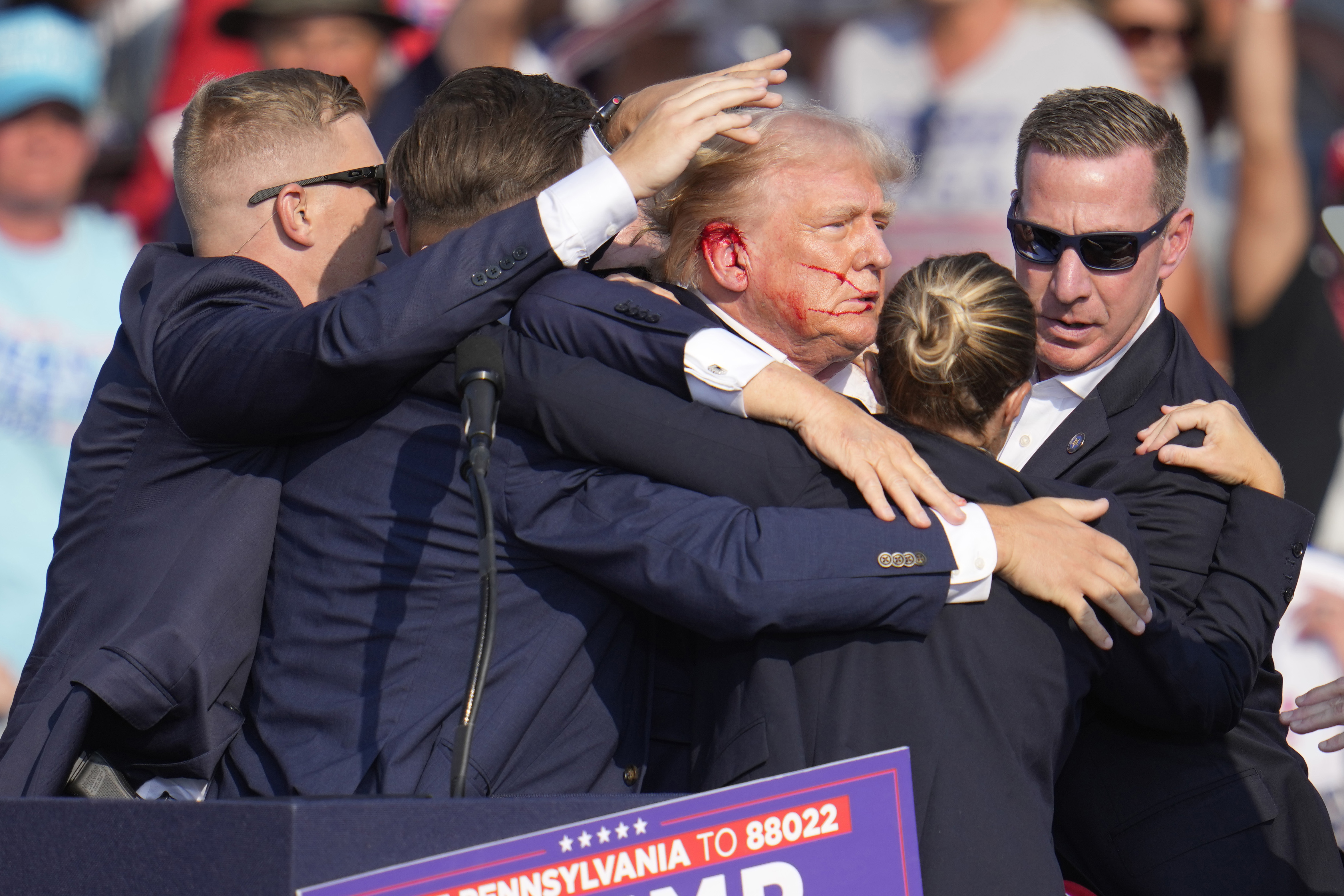 Former President Donald Trump is surrounded by Secret Service agents at a campaign rally in Butler, Pa., July 13. A new report Friday shows communication breakdowns with local law enforcement hampered the Secret Service's performance.