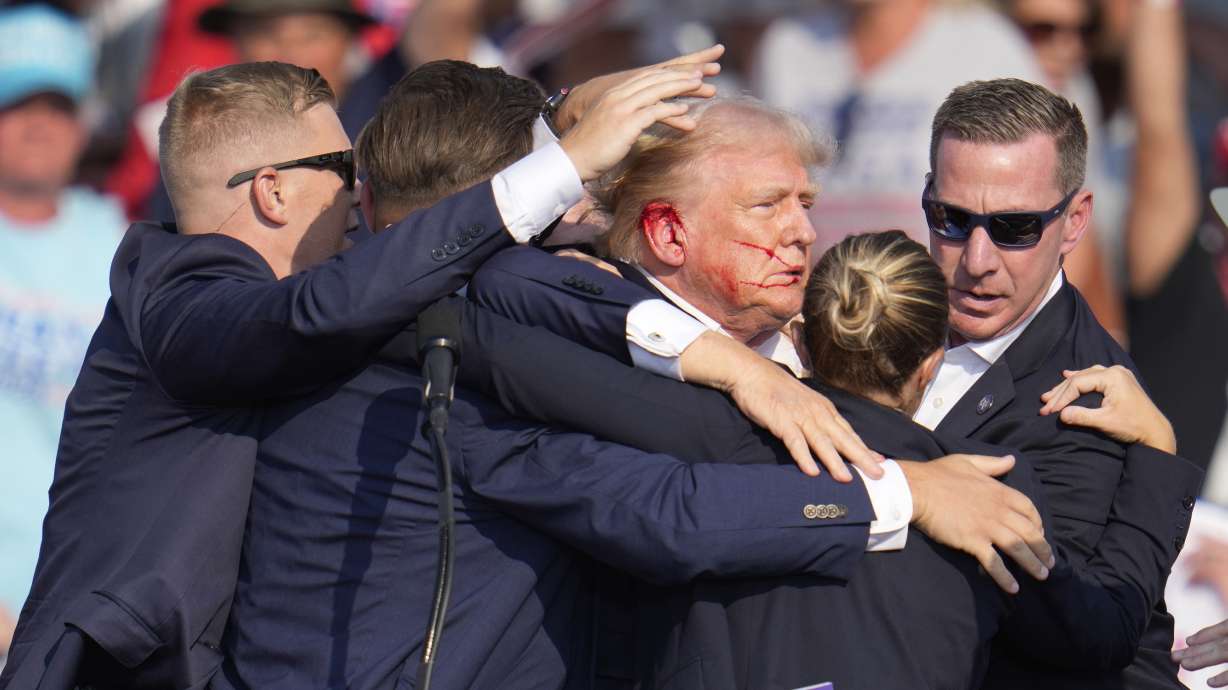 Former President Donald Trump is surrounded by Secret Service agents at a campaign rally in Butler, Pa., July 13. A new report Friday shows communication breakdowns with local law enforcement hampered the Secret Service's performance.