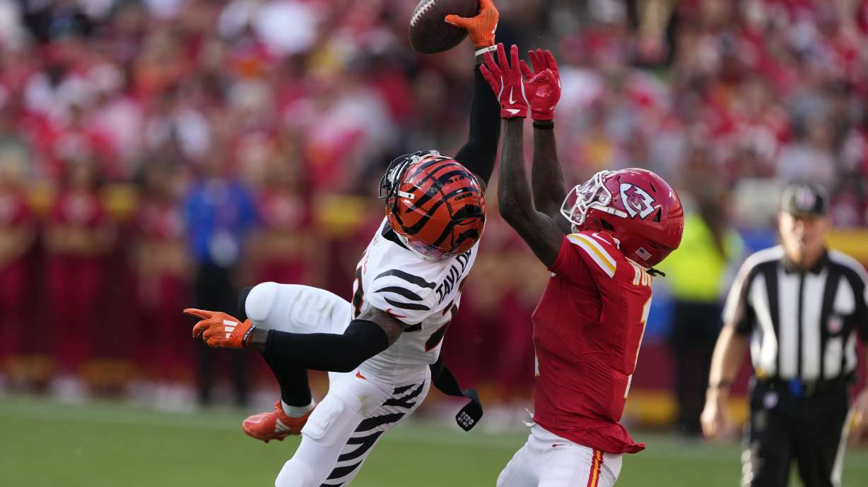 Cincinnati Bengals cornerback Cam Taylor-Britt, left, intercepts a pass intended for Kansas City Chiefs wide receiver Xavier Worthy during the second half of an NFL football game Sunday, Sept. 15, 2024, in Kansas City, Mo.