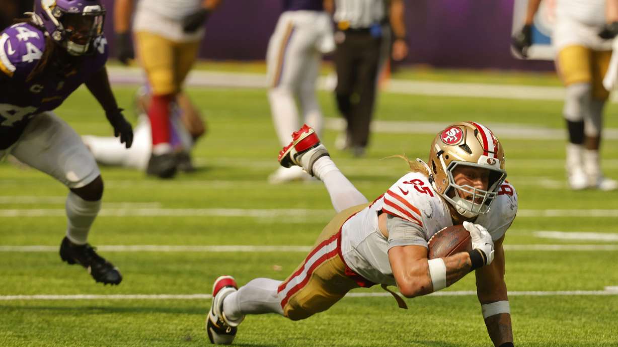 San Francisco 49ers tight end George Kittle (85) dives for extra yardage after catching a pass during the second half of an NFL football game against the Minnesota Vikings, Sunday, Sept. 15, 2024, in Minneapolis.