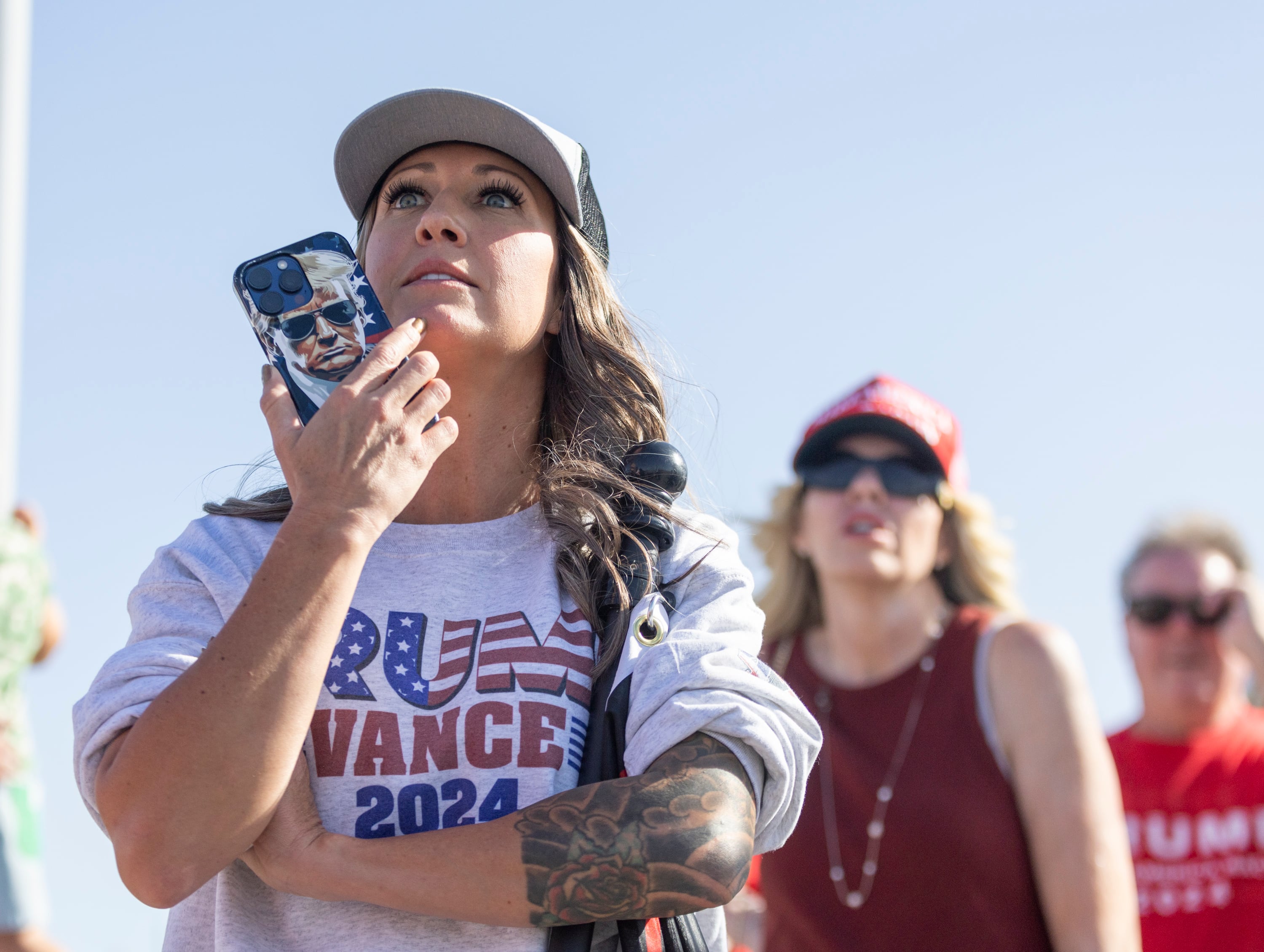 Bridget Whiting, from Heber, looks on, hoping to see presidential candidate and former President Donald Trump as he arrives at Salt Lake City International Airport for a fundraiser in Salt Lake City, Sept. 14.