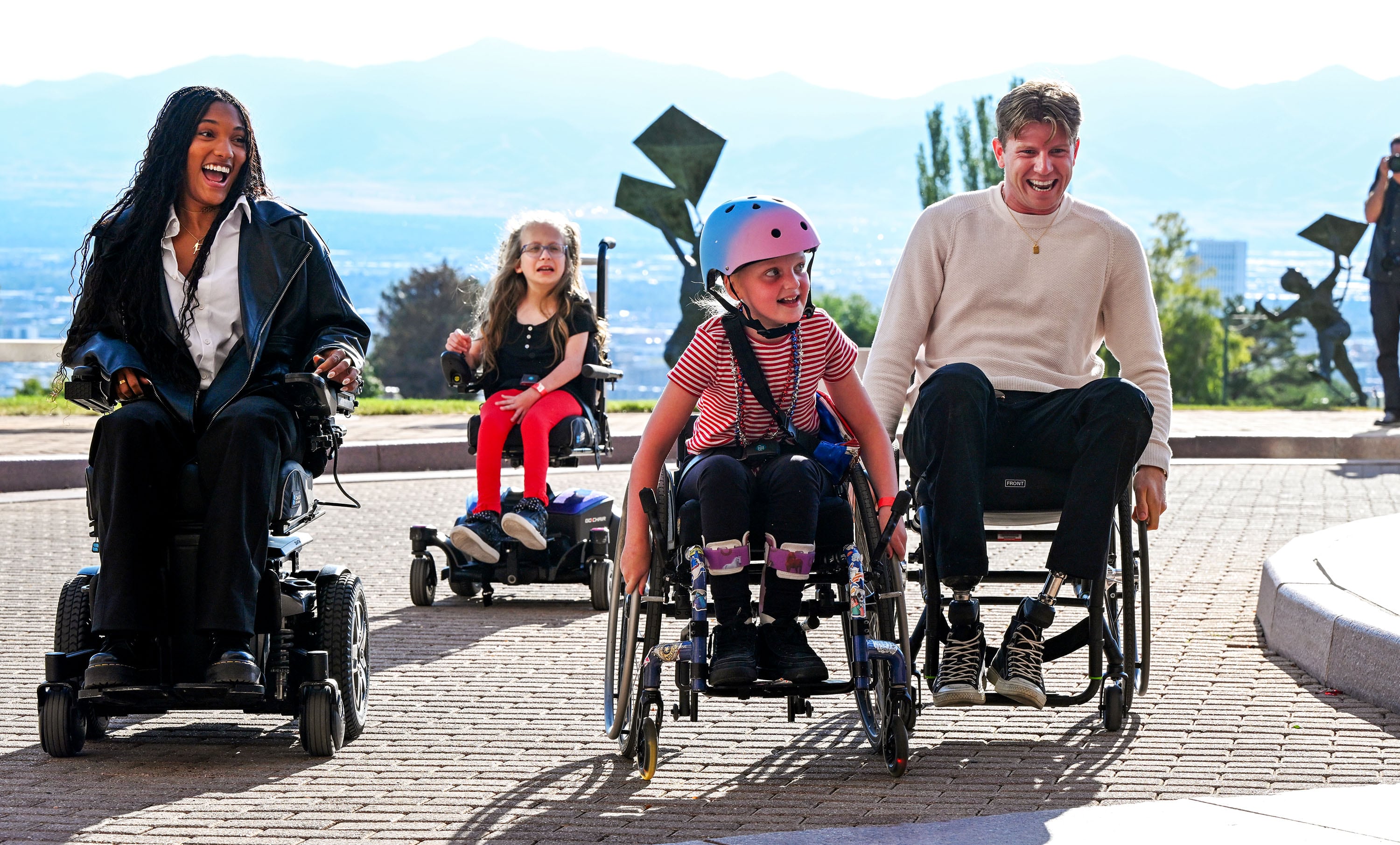 Tara Davis-Woodhall and Hunter Woodhall chase down Madi Sandstrom as they race during a visit to Shriners Children’s Hospital in Salt Lake City on Sept. 18. Hunter was a patient at the hospital when he was younger.