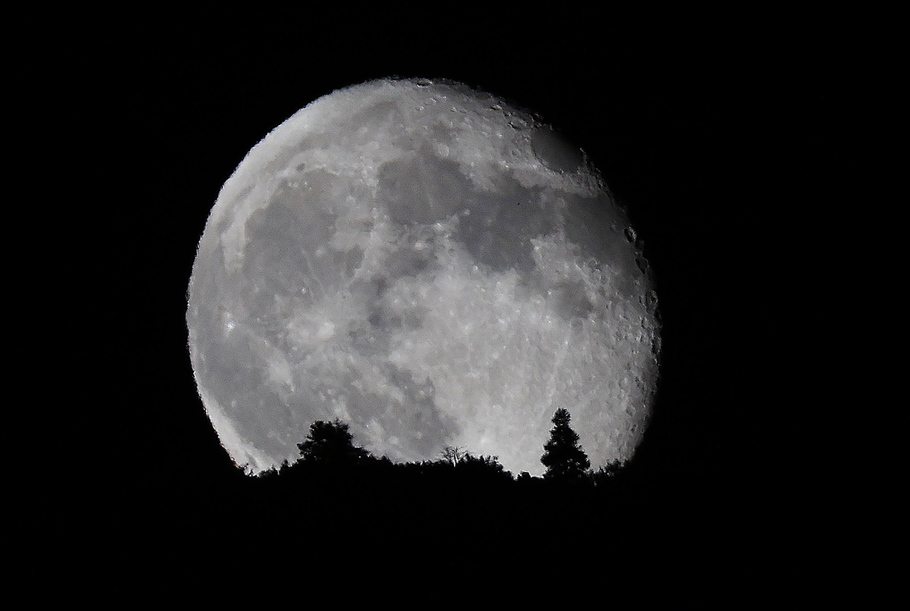 The waning gibbous moon rises over the mountains in Highland on Sept. 19.