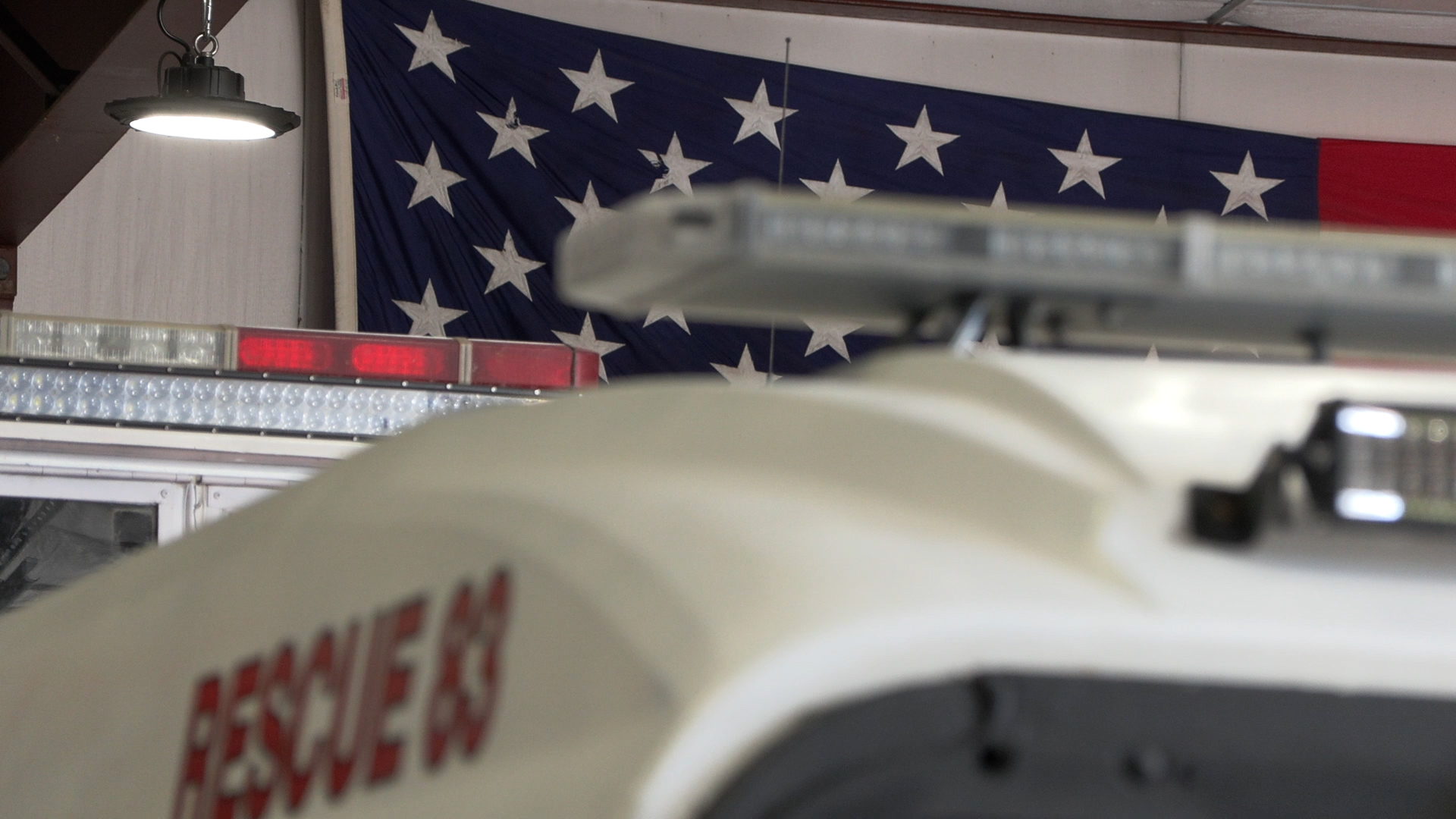 An American flag hangs over the emergency vehicles inside Terra Fire Department, where Neil volunteered for 44 years.