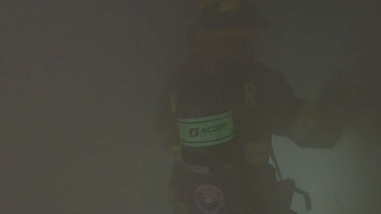 One of the participants in the smoke-filled room looking for the fake baby.