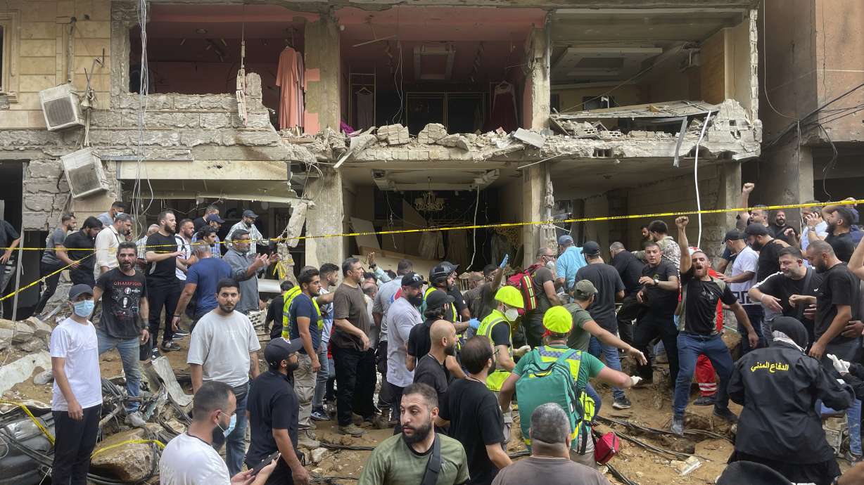 People gather near a damaged building at the scene of an Israeli missile strike in the southern suburbs of Beirut, Friday. The Biden administration is taking a more hands-off approach during a week of dramatic escalation.