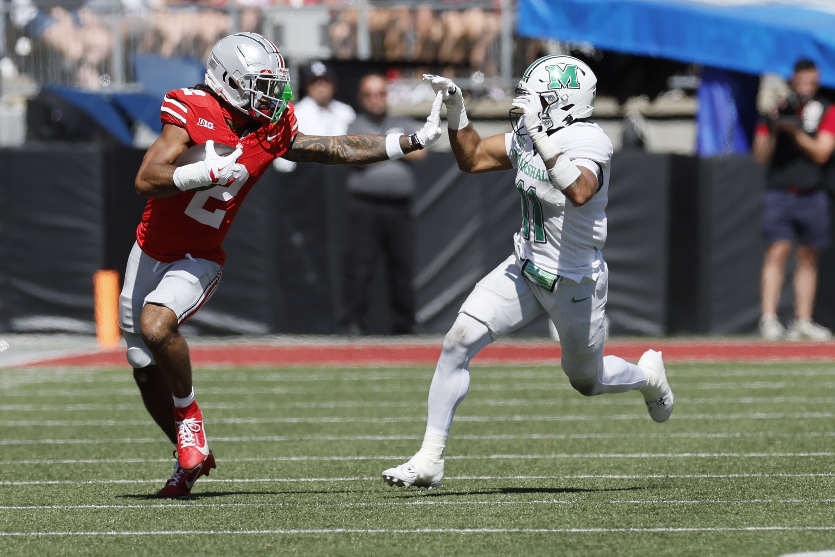 Ohio State receiver Emeka Egbuka, left, tries to stiff arm Marshall defensive back J.J. Roberts during the first half of an NCAA college football game Saturday, Sept. 21, 2024, in Columbus, Ohio.