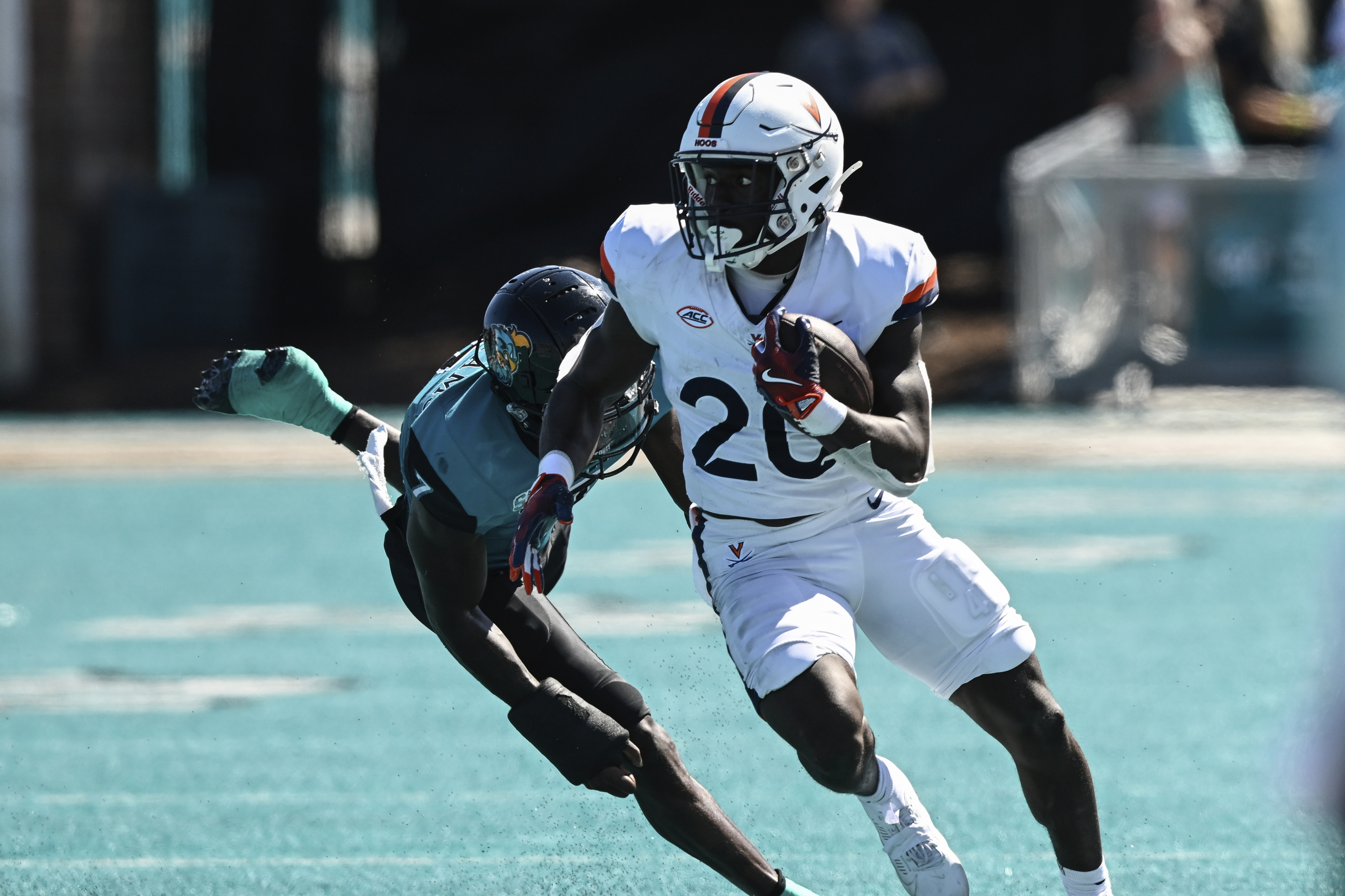 Virginia running back Xavier Brown (20) runs past Coastal Carolina safety AJ Williams (7) during the first half of an NCAA college football game on Saturday, Sept. 21, 2024, in Conway, S.C.