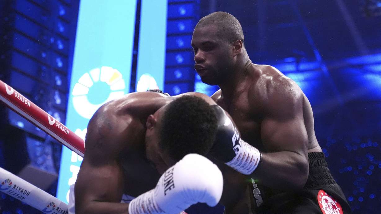 Daniel Dubois, right, knocks down Anthony Joshua in the IBF World Heavyweight bout at Wembley Stadium, in London, Saturday Sept. 21, 2024.