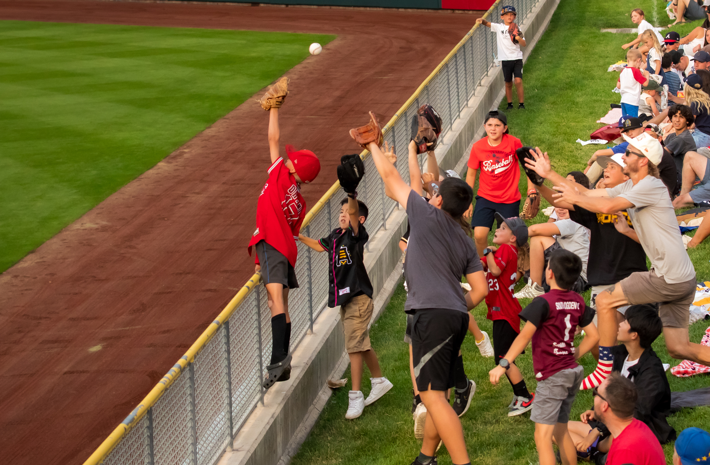 Fans fight over a ball tossed into the crowd at Smith's Ballpark on July 24.