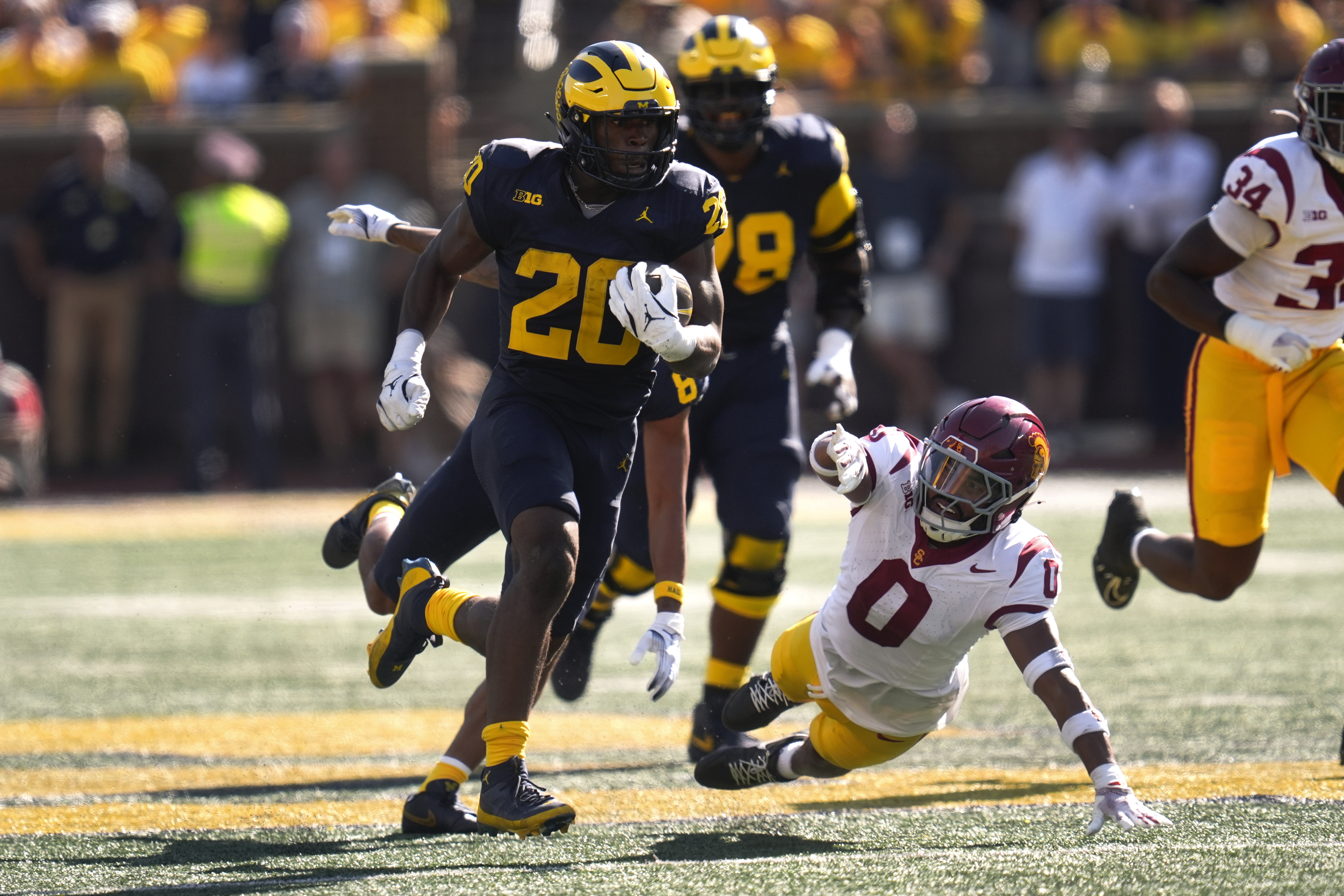 Michigan running back Kalel Mullings (20) runs for a 53-yard touchdown as Southern California safety Akili Arnold (0) defends in the first half of an NCAA college football game in Ann Arbor, Mich., Saturday, Sept. 21, 2024.
