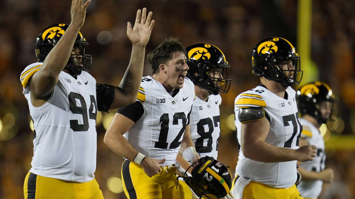 Iowa quarterback Cade McNamara (12) celebrates with teammates after a one-yard touchdown run by quarterback Brendan Sullivan during the second half of an NCAA college football game against Minnesota, Saturday, Sept. 21, 2024, in Minneapolis.