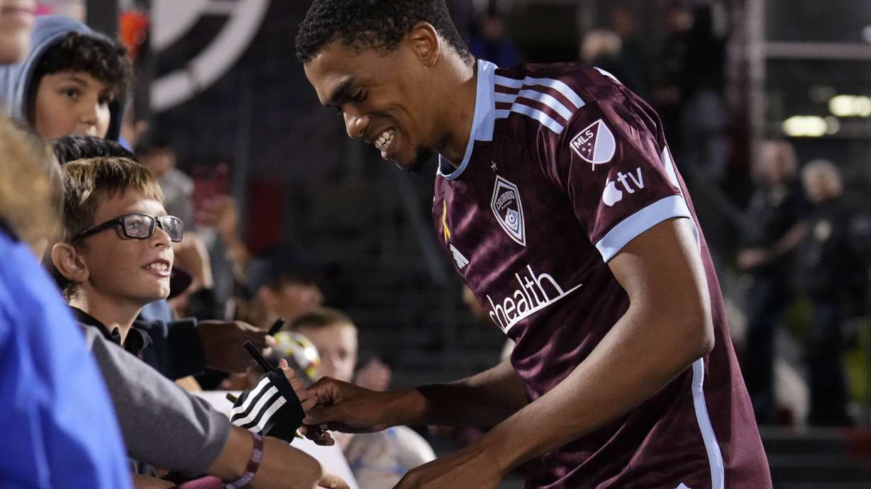 Colorado Rapids defender Reggie Cannon, right, smiles while giving autographs after an MLS soccer match against Toronto FC Saturday, Sept. 21, 2024, in Commerce City, Colo.