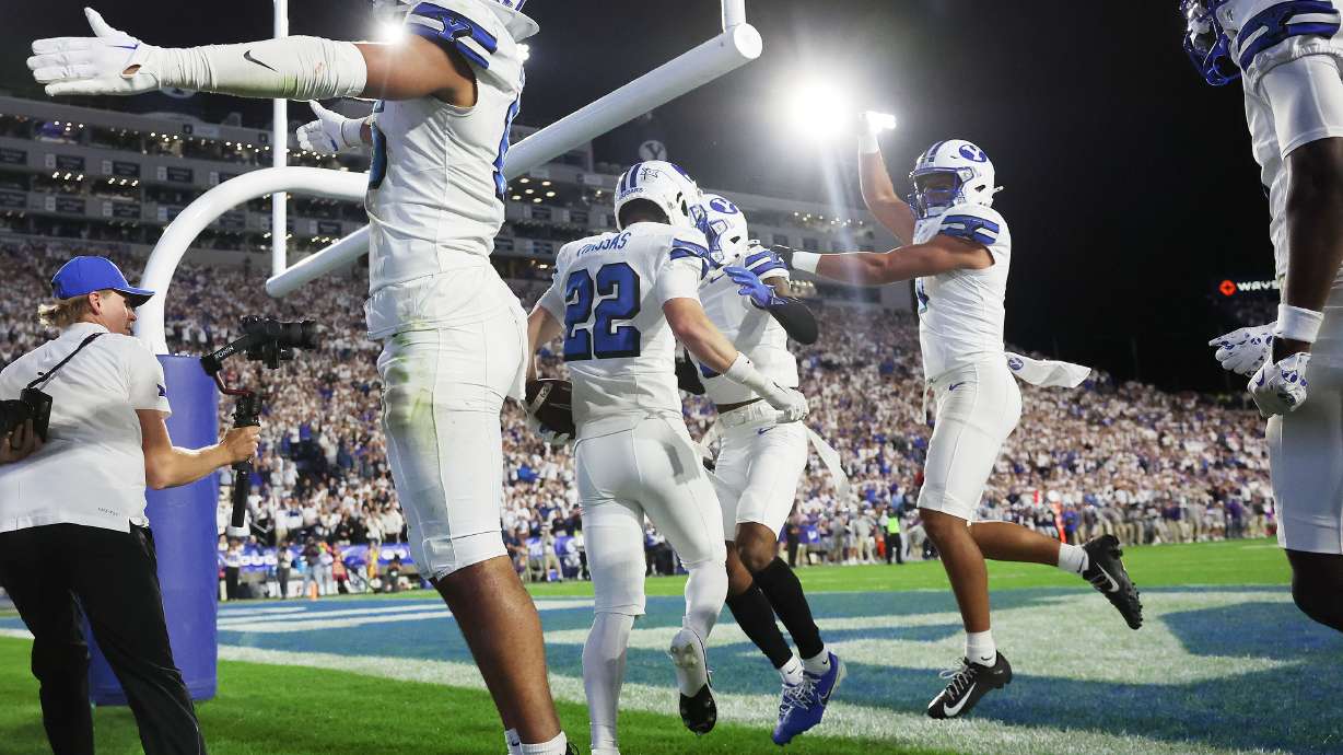 Brigham Young safety Tommy Prassas (22) andf teammates celebrate a fumble recovery and touchdown with Brigham Young Cougars cornerback Marque Collins (4) in Provo on Saturday, Sept. 21, 2024.