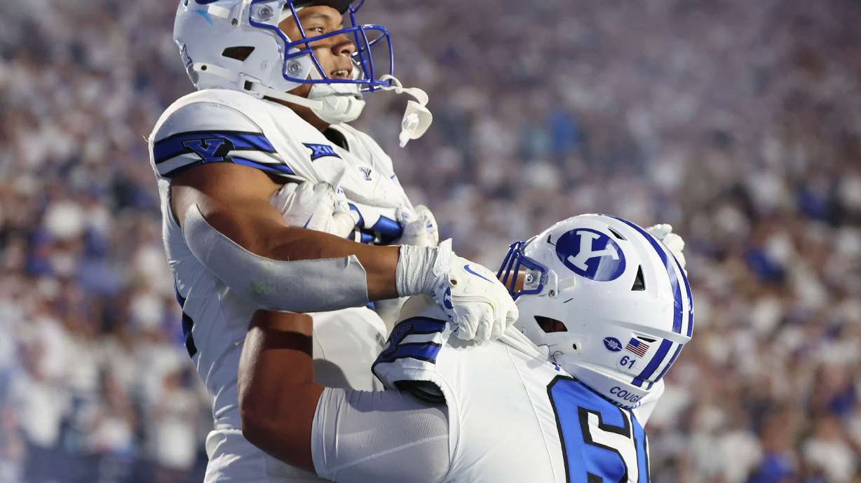 Brigham Young running back Sione I Moa (30) celebrates his touchdown with Brigham Young Cougars offensive lineman Weylin Lapuaho (61) in Provo on Saturday, Sept. 21, 2024. BYU won 38-9.