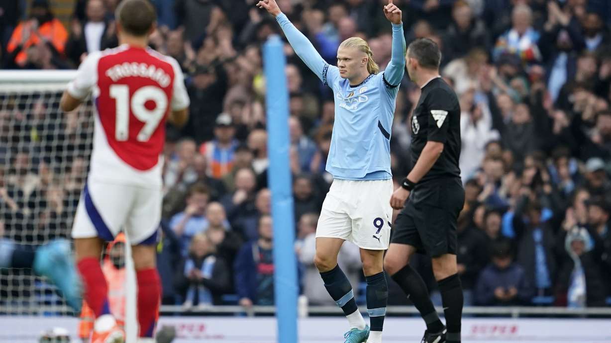 Manchester City's Erling Haaland, center, celebrates after scoring his side's opening goal during the English Premier League soccer match between Manchester City and Arsenal at the Etihad stadium in Manchester, England, Sunday, Sept. 22, 2024.