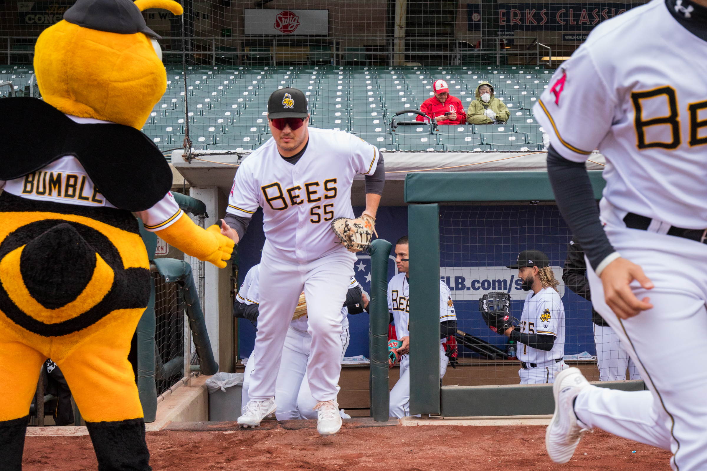 Salt Lake Bees first baseman Sonny DiChiara slaps hands with Salt Lake Bees mascot Bumble as the team runs onto the field for a game on April 6.