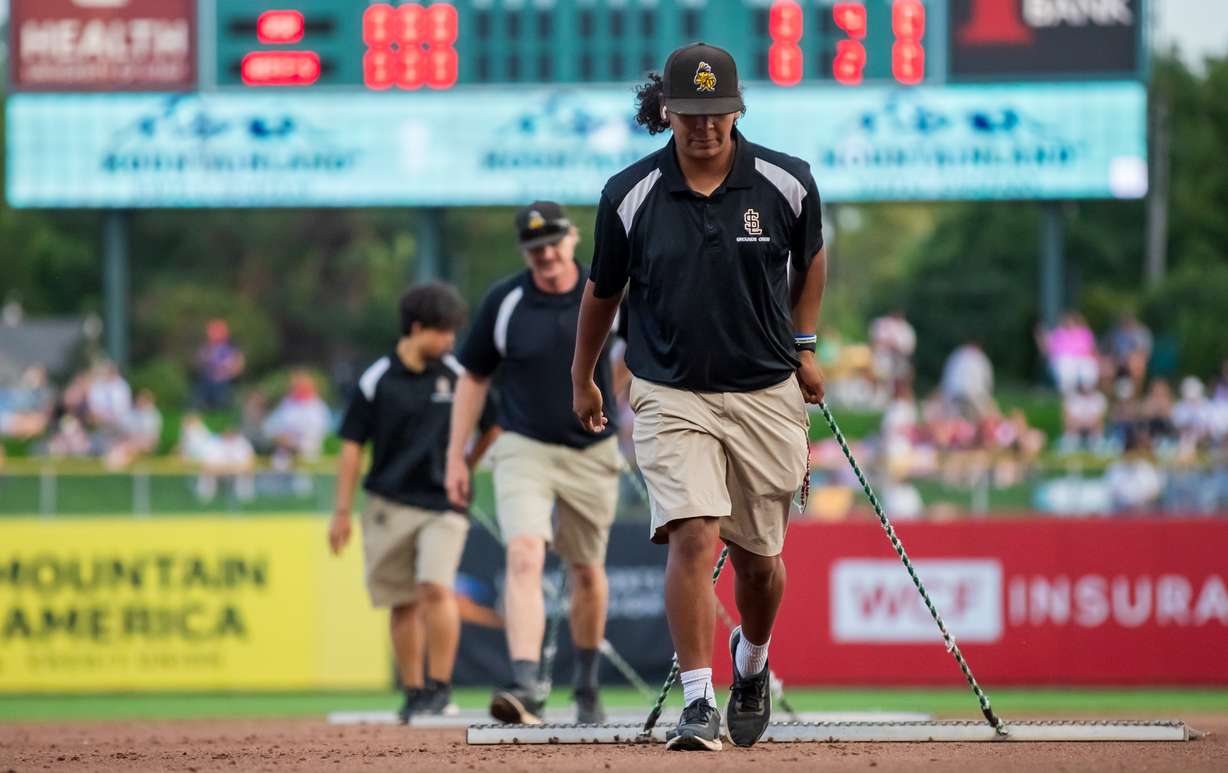 Members of the Salt Lake Bees grounds crew use rigid drags to clean the base paths between innings during a Salt Lake Bees game at Smith's Ballpark on Aug. 24.
