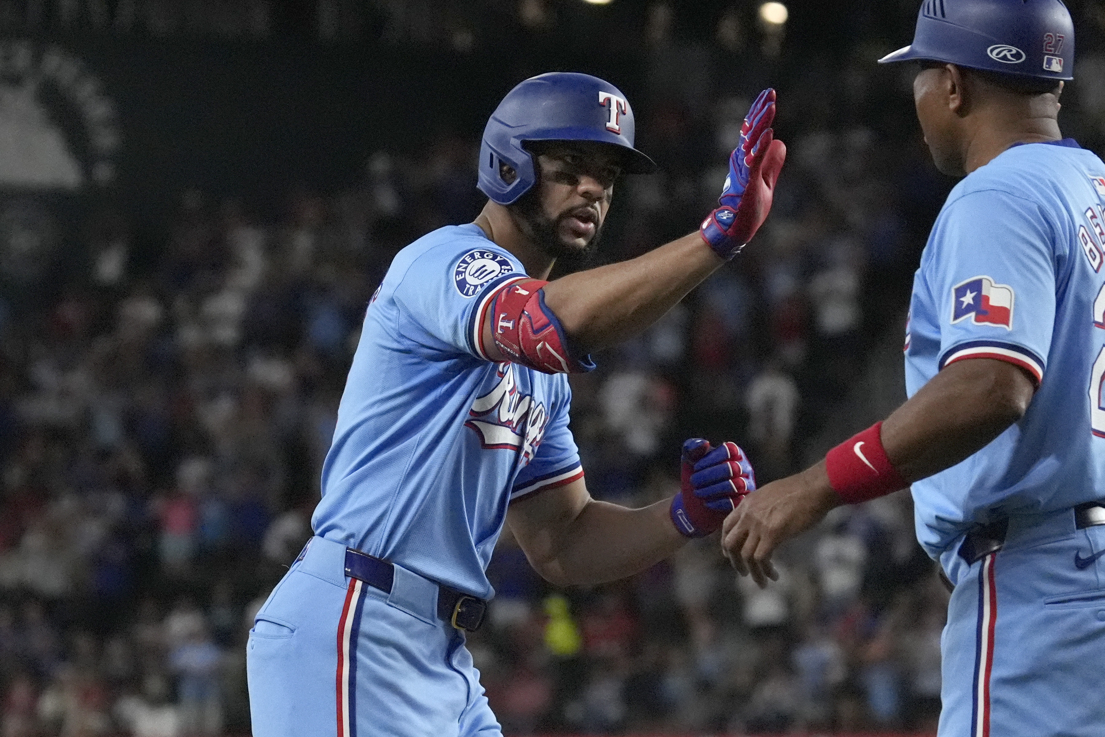 Texas Rangers' Leody Taveras, left, is congratulated by third base coach Tony Beasley, right, after hitting a home run during the seventh inning of a baseball game against the Seattle Mariners, Sunday, Sept. 22, 2024, in Arlington, Texas. 